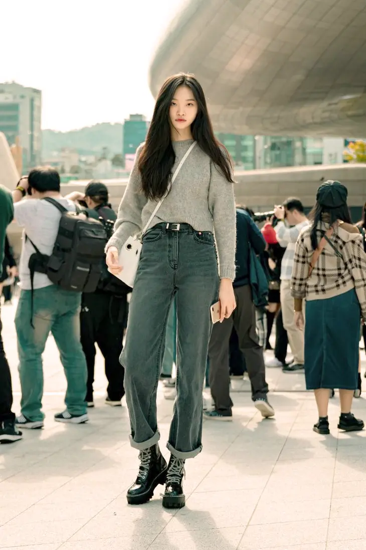 A Korean fashion designer showcasing their latest collection on the runway, highlighting the innovative designs and avant-garde aesthetics that define Korean women's fashion on the global stage